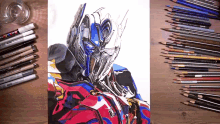 a drawing of optimus prime surrounded by colored pencils and markers