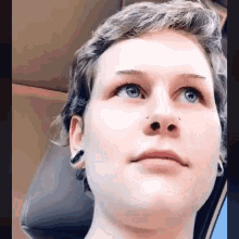 a close up of a person 's face with a nose ring