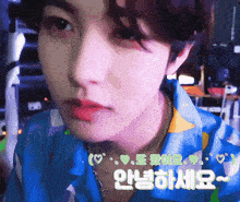 a close up of a young man 's face with korean writing on it