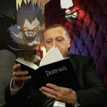 a man in a suit is reading a book titled death note .