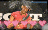 a man wearing headphones and a red shirt is standing in front of a sign that says t.
