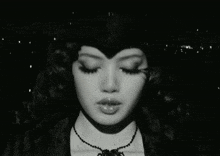 a black and white photo of a woman wearing a hat