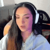 a woman wearing headphones is sitting in front of a computer screen .