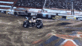 a monster truck is driving down a dirt track with a jcb banner in the background