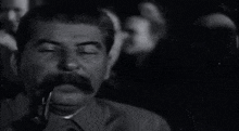 a man with a mustache and a pipe in his mouth