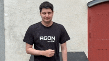 a man wearing a black agon by aoc t-shirt