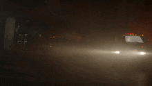an ambulance is driving down a street at night