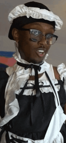 a man dressed as a maid wearing glasses and a black hat