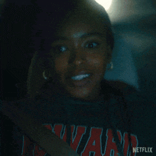 a woman sitting in a car wearing a netflix shirt