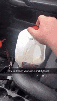 someone is holding a gallon of milk in a car