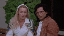 a man and a woman are sitting next to each other and the woman is wearing a white headband