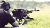 a man wearing headphones is aiming a rifle at a target