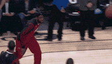 a basketball player wearing red pants and a black shirt with the number 9 on it