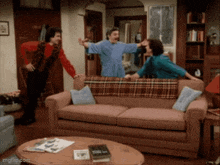 three people are standing around a couch in a living room with imgflip.com at the bottom