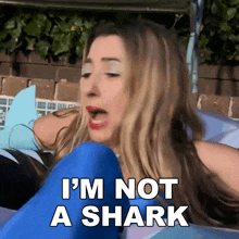 a woman is laying in a pool and says i 'm not a shark on the screen