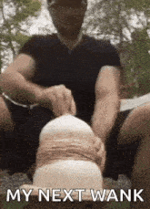 a man is sitting on the ground with his legs crossed and the words my next wank written on the bottom .