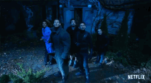 a group of people standing in front of a building with netflix written on the bottom right