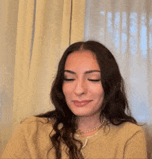 a woman giving the middle finger in front of a curtain