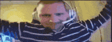 a pixelated image of a man wearing headphones and a striped sweater