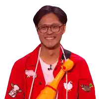 a man wearing glasses and a red jacket holds a stuffed chicken