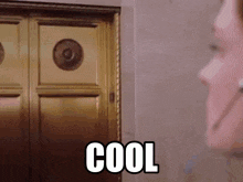 a woman standing in front of a door with the word cool written on it