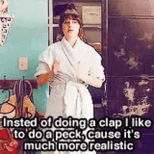 a woman in a bathrobe is doing a clap because it 's much more realistic than doing a peck .