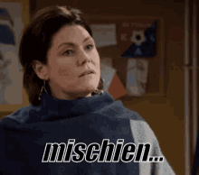 a woman is standing in front of a bulletin board and says mischien