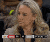 a woman is sitting in front of a scoreboard that says ion