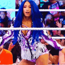 a woman with blue hair is standing in a ring