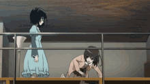 a girl in a blue dress is standing next to a girl in a pink suit on a balcony
