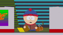 stanley from south park sits in front of a sign that says e