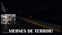 a man sitting in front of a screen that says viernes de terror on it