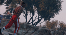 a shirtless man in red pants is standing in front of a sign that says sale