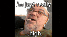a man with glasses and a beard is smoking a cigarette and the caption says i 'm just really high