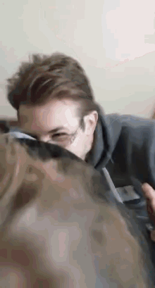 a man wearing glasses is laying on a couch and looking at something