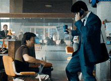 a man in a suit is talking on a cell phone while holding a newspaper that says ' report '