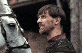 a man with a beard stands next to a white horse with a gif of a man standing next to a horse