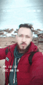 a man in a red jacket takes a selfie with the date dec 08 18 on the bottom