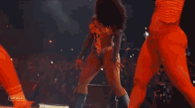 a woman in a bodysuit is dancing in front of a crowd with the words coachella on the bottom right