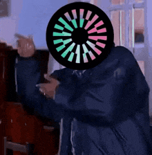 a man in a blue coat is standing in front of a piano while wearing a colorful circle on his head .