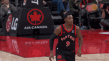 a basketball player wearing a number 9 raptors jersey
