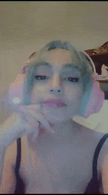 a woman with green hair and pink headphones on