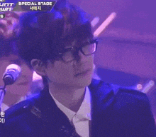 a man stands on a stage with a sign above him that says special stage