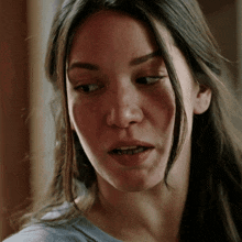 a close up of a woman 's face with a blue shirt on