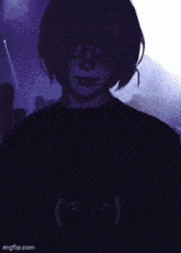 a girl wearing glasses and a blue shirt with a smiley face on the front