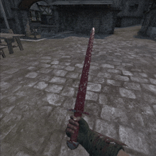 a person holding a bloody sword on a brick floor