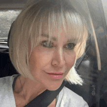 a woman in a car with a seat belt around her neck
