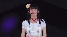 a girl wearing a white dress with flowers on it and a microphone
