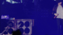 a blurry photo of a person on a stage with the letter d in the lower right corner