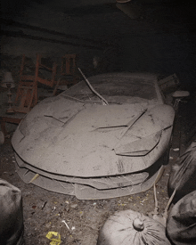 a dirty car with a broken windshield is in a dark room